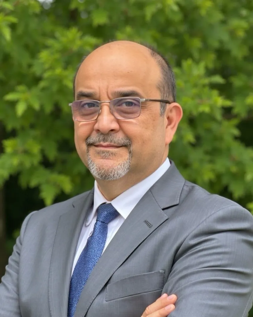 Dr. Hugo Miranda, traumatólogo, con traje gris y los brazos cruzados